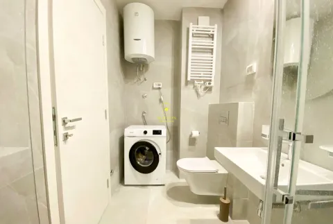 Modernly equipped bathroom with a washing machine and a water heater. - image 4