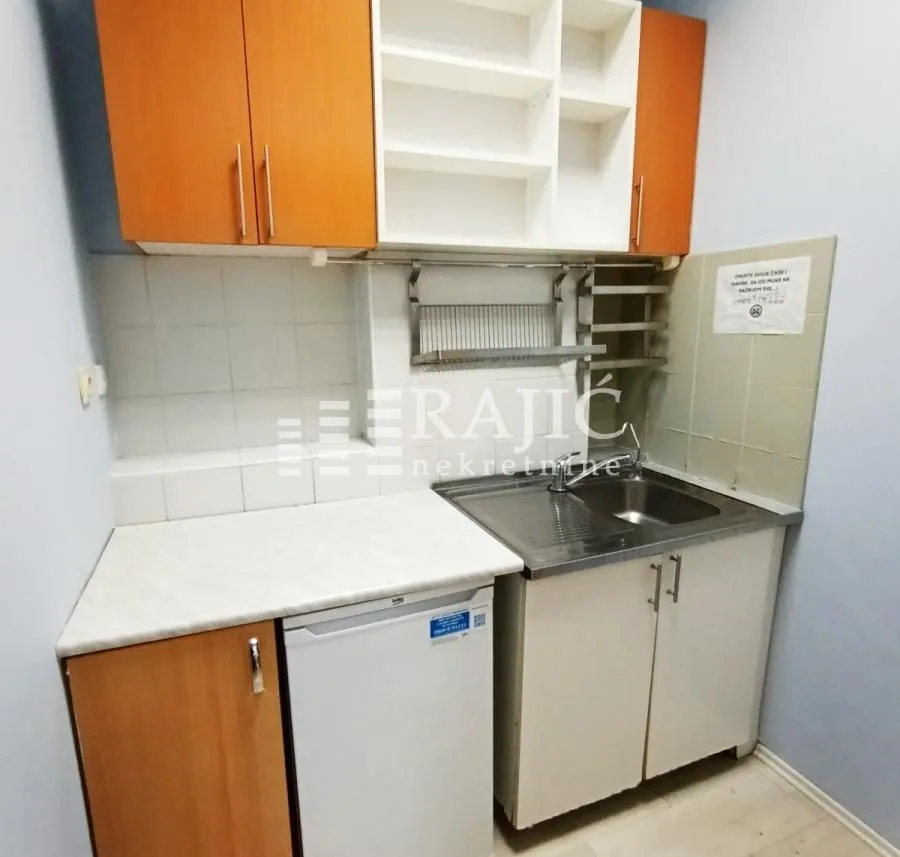 Small kitchen with wooden cabinets and sink.