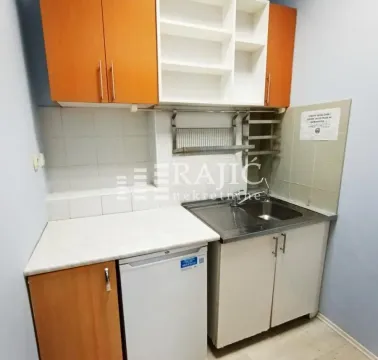 Small kitchen with wooden cabinets and sink. - image 13