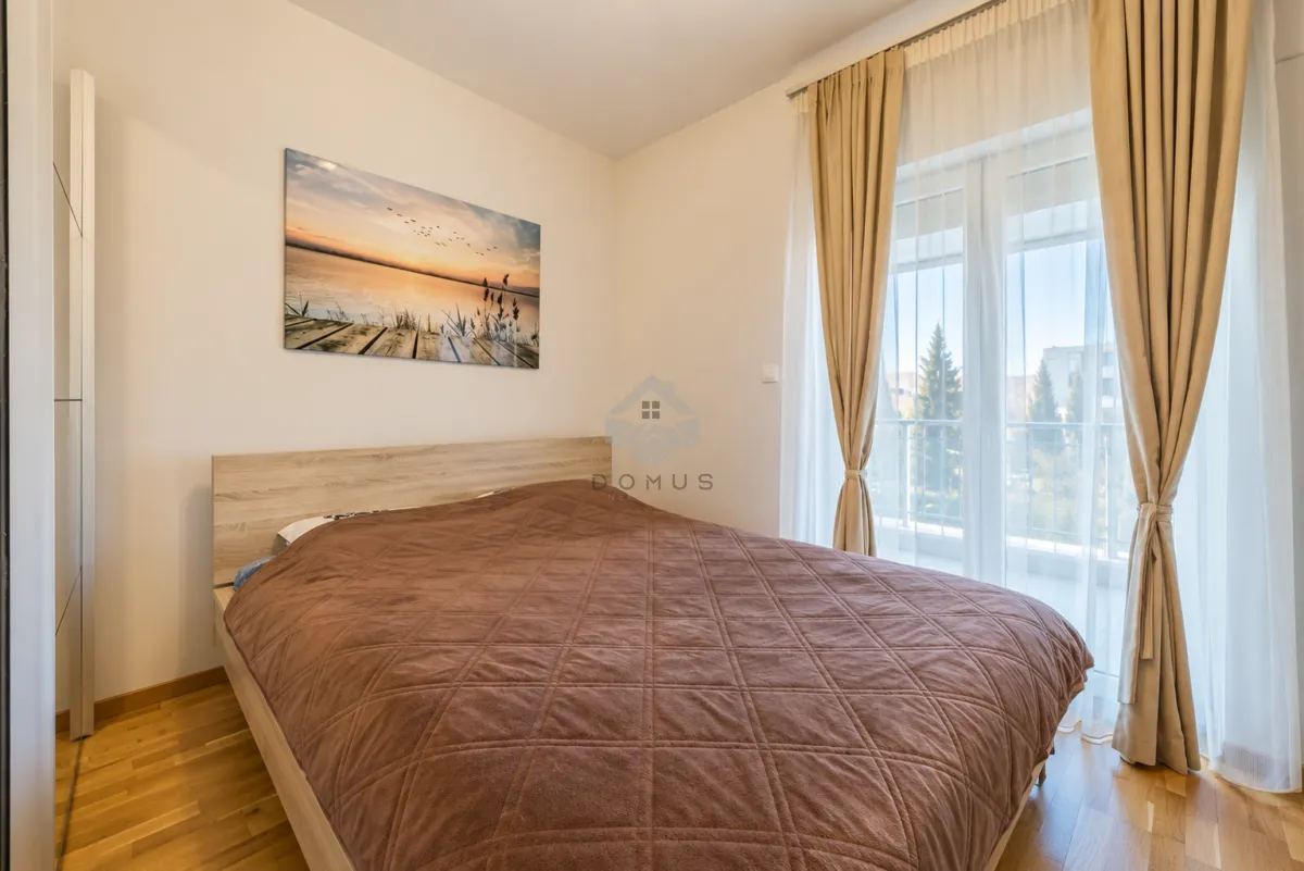 Bedroom with a double bed, wooden floor and access to the terrace.
