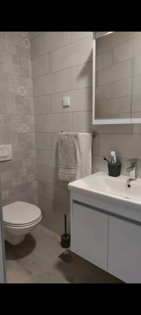 Modern bathroom with a washbasin, toilet, and a mirror cabinet.