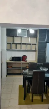 Kuhinja sa otvorenim policama i trpezarijskim stolom u prvom planu. - image 3