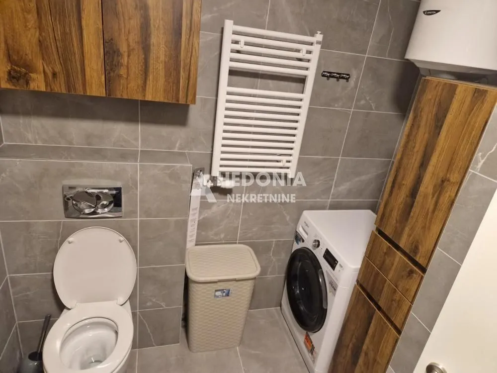 Bathroom equipped with sanitary fixtures, a towel radiator, and a washing machine.