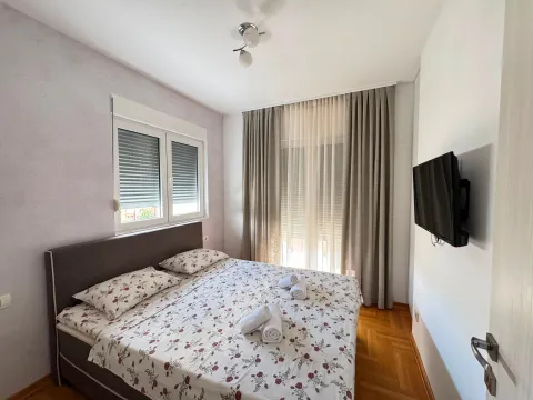 Bedroom with a double bed and a wall-mounted TV. - image 9