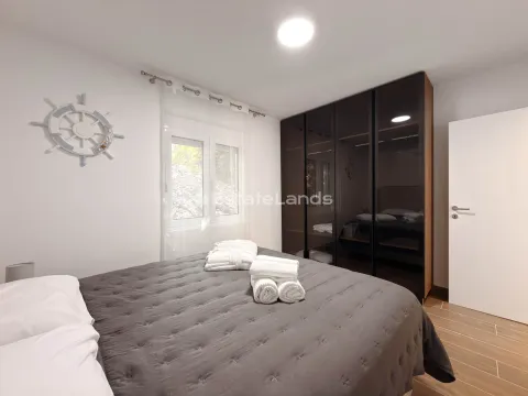 Uređena spavaća soba sa bračnim krevetom, velikim garderoberom i ukrasnim detaljima na zidu. - image 15