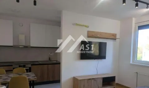 Living room with a TV and a dining area in the background. - image 2