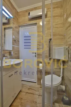 Kupatilo opremljeno sanitarijama, umivaonikom i tuš kabinom. - image 15