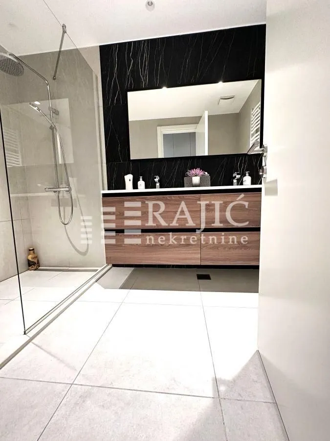 Modern bathroom with a walk-in shower and vanity.