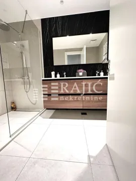Modern bathroom with a walk-in shower and vanity. - image 13