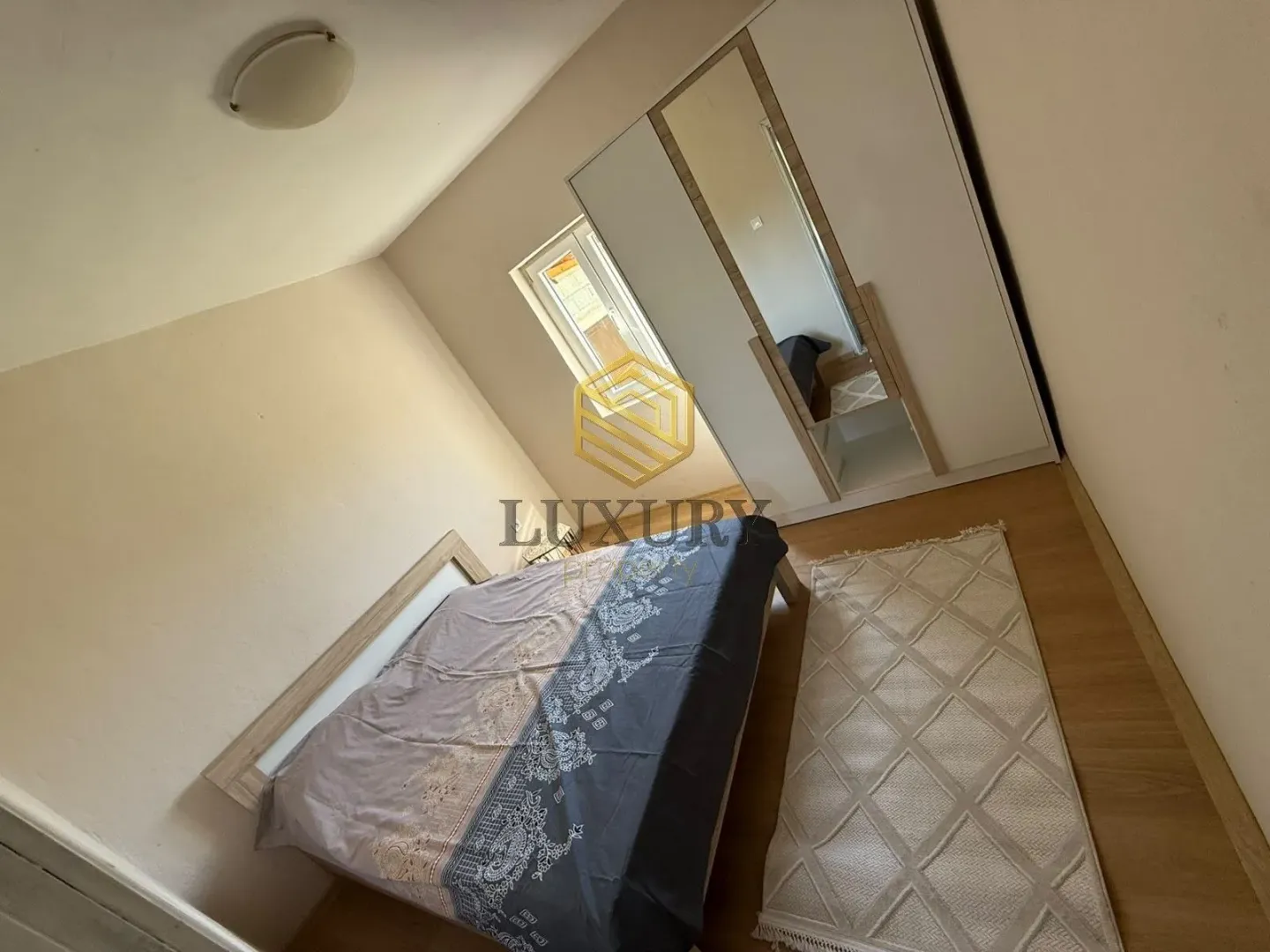 Bedroom with a double bed, wardrobe, and a window.