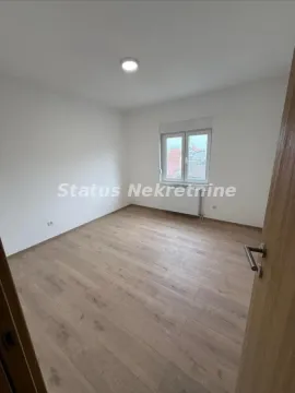 Prazna soba sa belim zidovima, parketom i jednim prozorom. - image 5