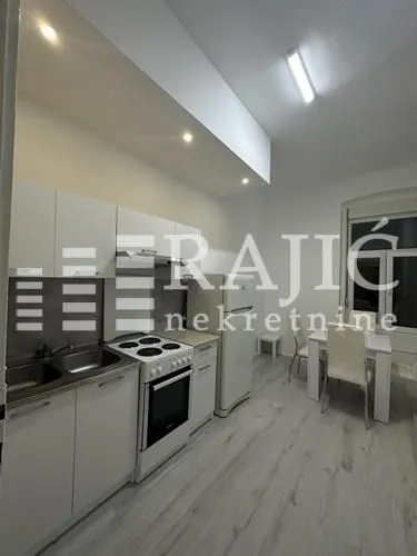 Small white kitchen with a dining area.