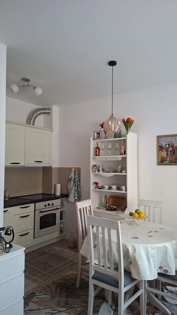 Kuhinja sa trpezarijom i bijelim elementima.