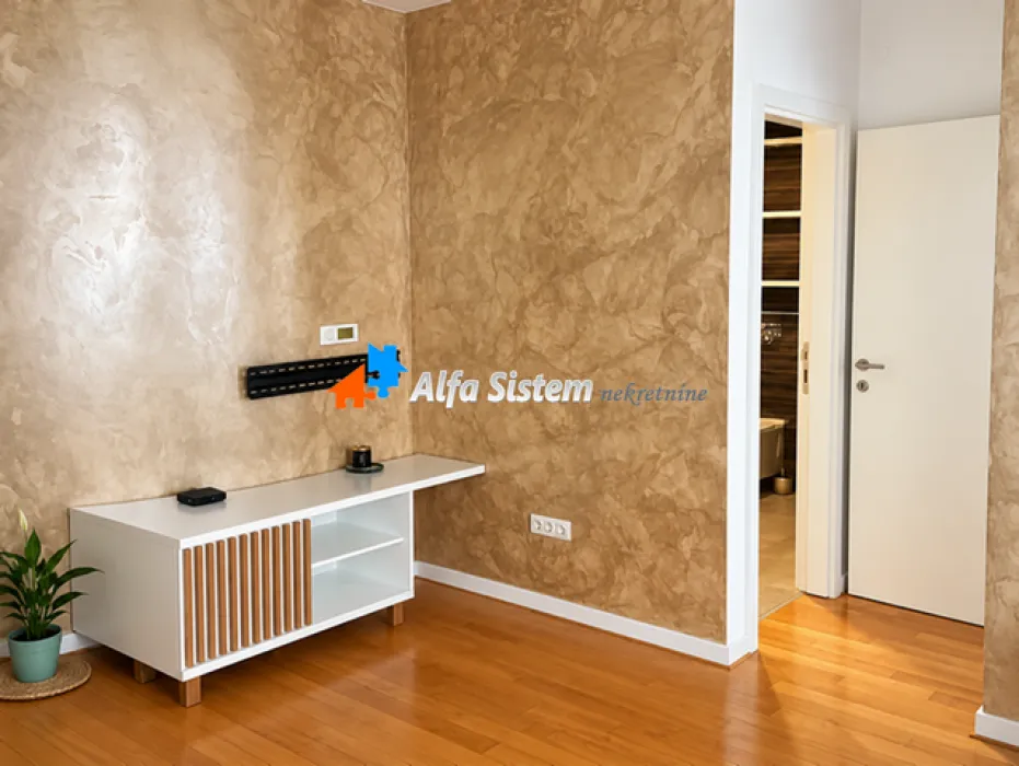 View of a part of the living room with a TV unit and a decorative wall.