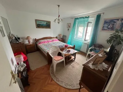Furnished bedroom with a double bed, wooden furniture, and a window with green curtains. - image 10