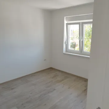 Prazna soba sa belim zidovima i drvenim podom. - image 16