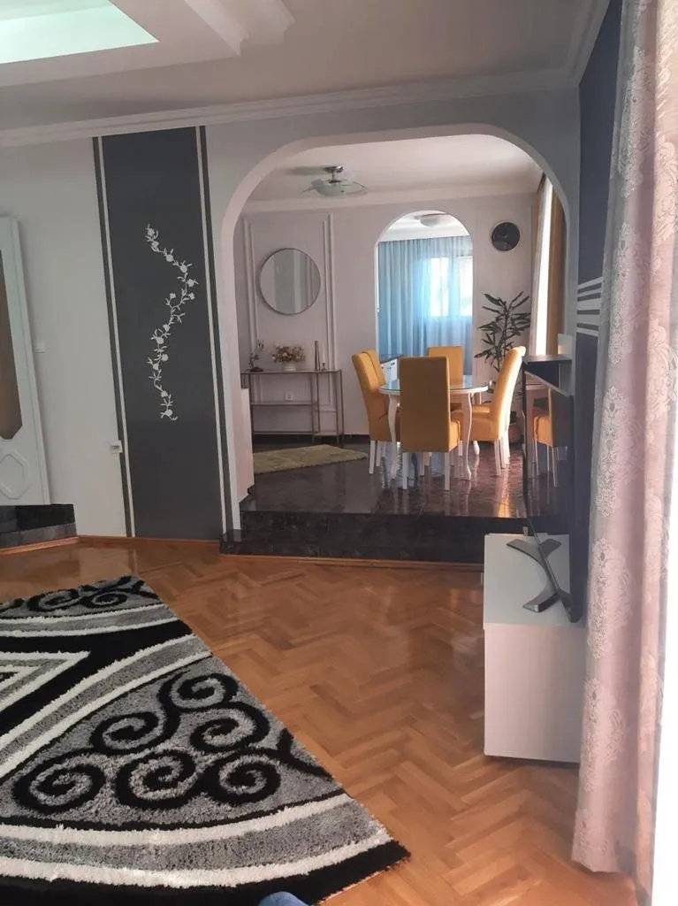 View from the living room towards the dining area with a raised floor and arched doorway.
