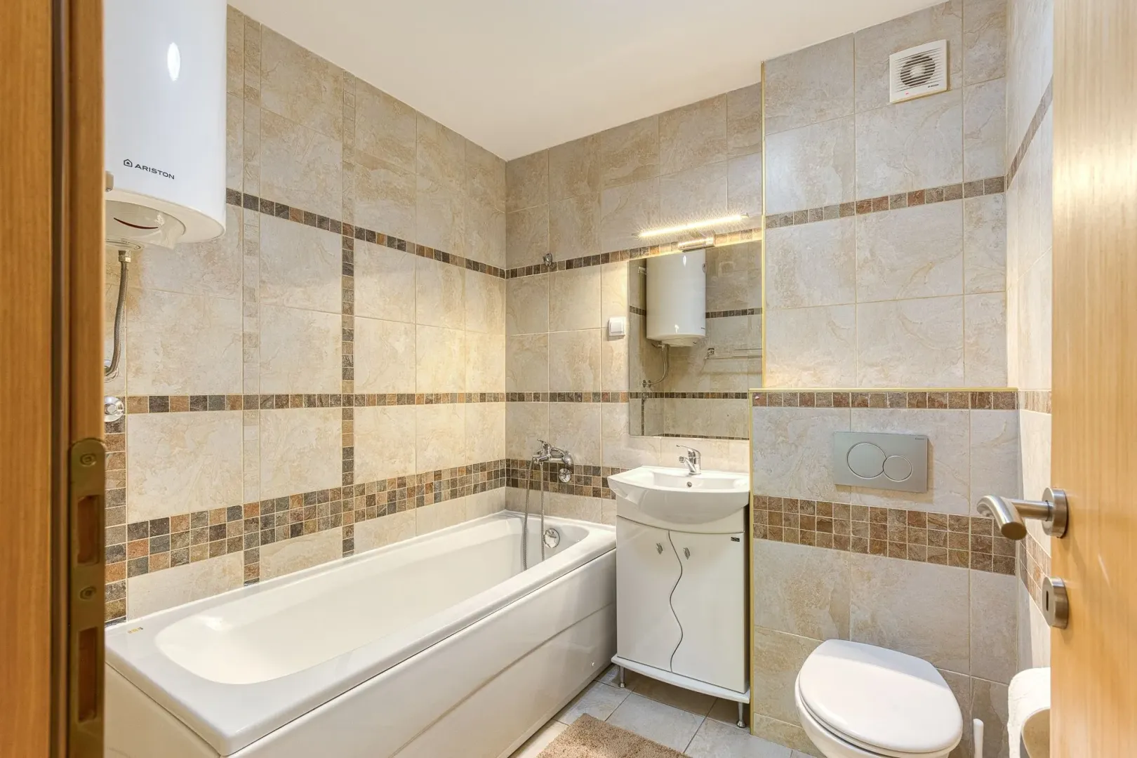 Fully equipped bathroom with a bathtub, sink, and toilet.