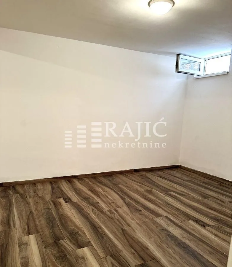 Empty room with laminate flooring and a small window.