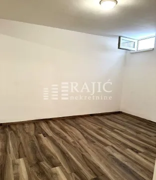 Empty room with laminate flooring and a small window. - image 10