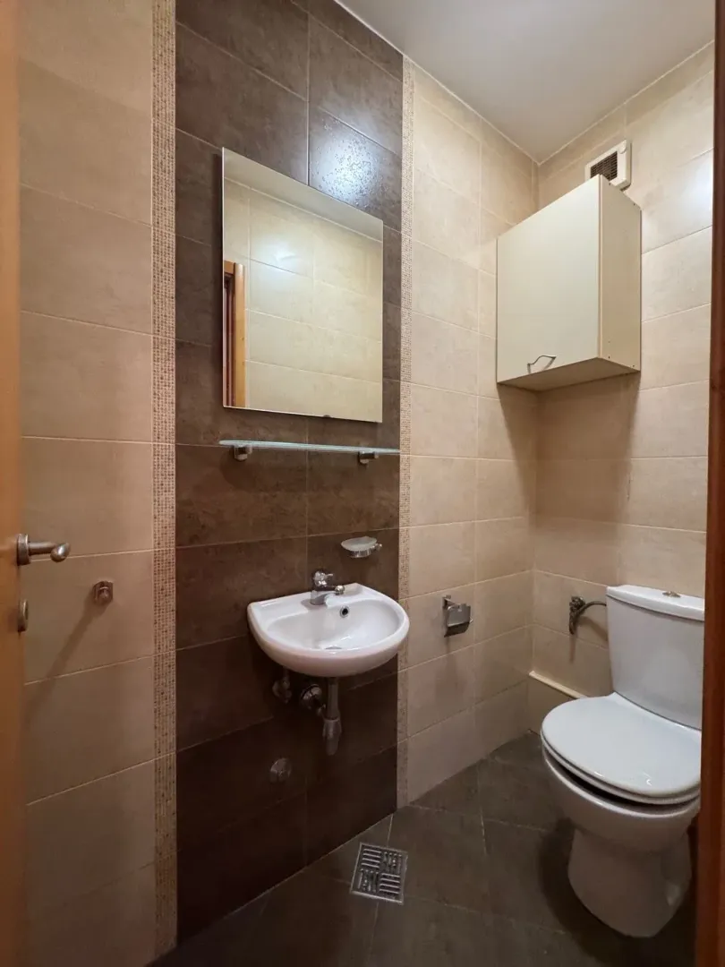 Smaller bathroom with a washbasin, mirror, and toilet.