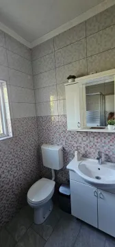 Small bathroom with a sink, mirrored cabinet, and toilet. - image 7