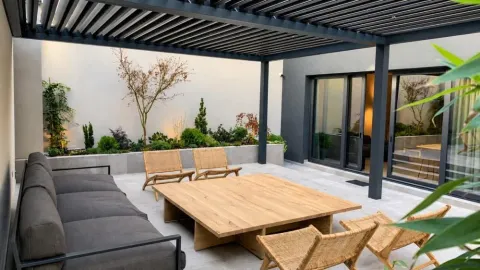 Modern covered terrace with seating furniture and a landscaped courtyard. - image 10