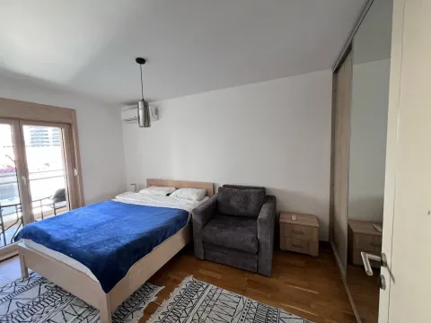 Furnished bedroom with a double bed, armchair, and wardrobe. - image 18