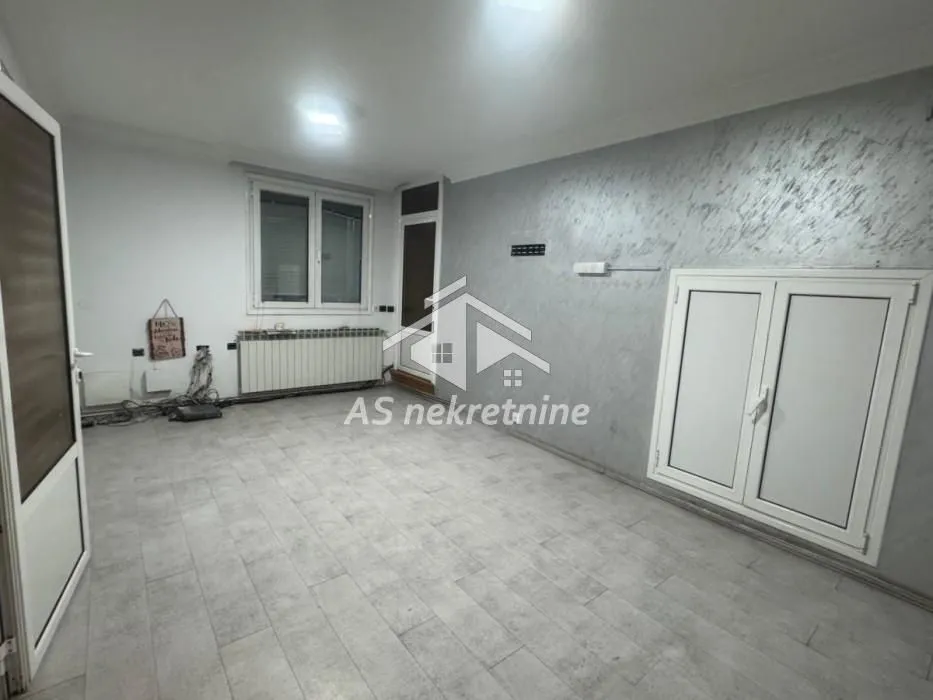 An empty room with grey walls and ceramic tile flooring.
