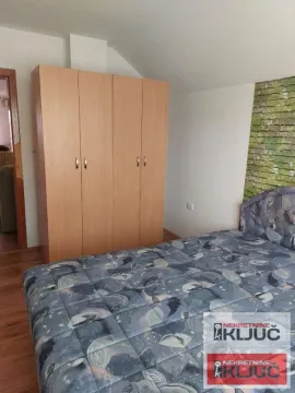 Nameštena spavaća soba sa bračnim krevetom i drvenim ormanom. - image 3