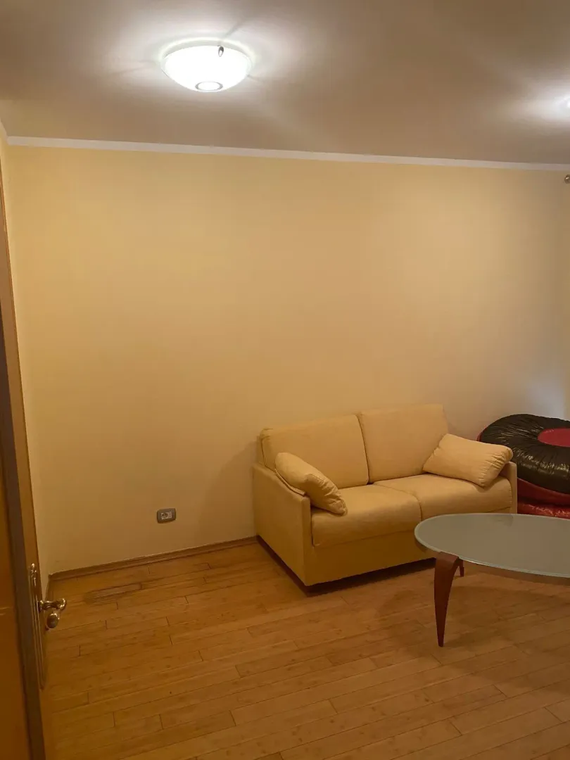 Jednostavan dnevni boravak sa svijetlim dvosjedom i klub stolom.