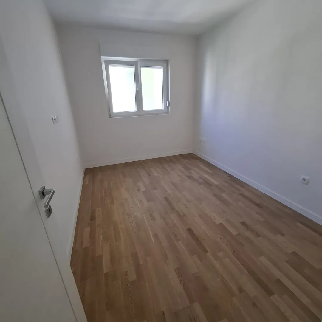 Empty room with hardwood floors and a window.