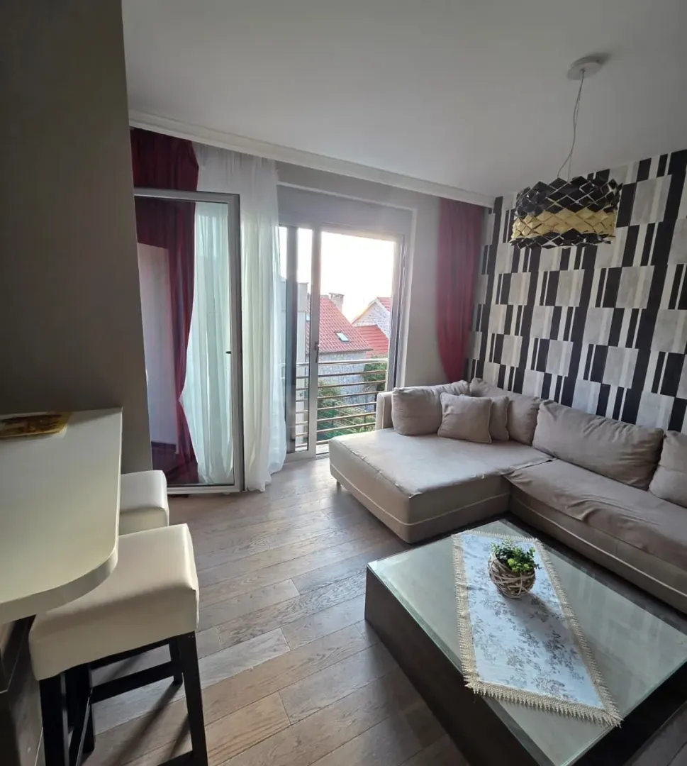 Living room with a sectional sofa, coffee table, and access to the terrace.