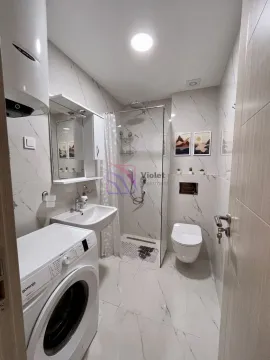 Modernly equipped bathroom with a walk-in shower and washing machine. - image 7