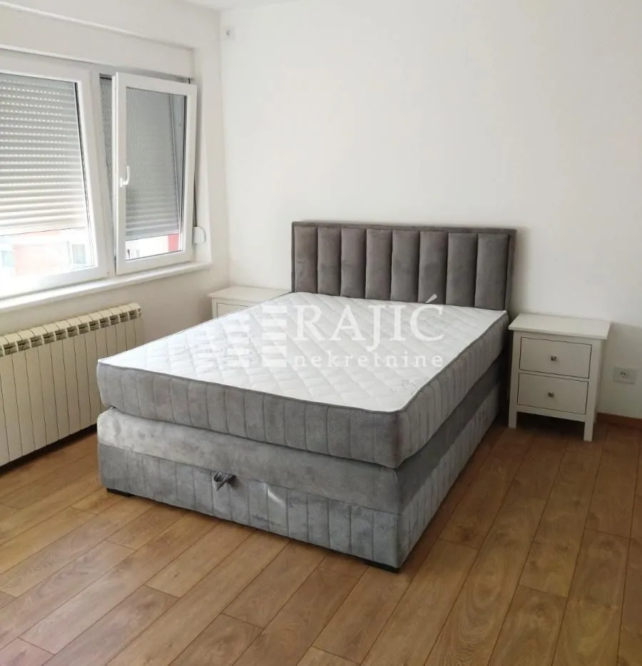 Furnished bedroom with a double bed and a nightstand.