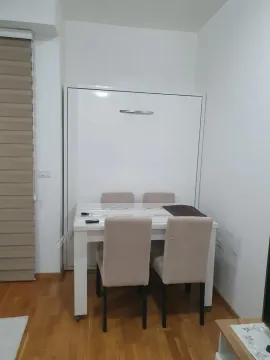 Living room with a dining table and a wall bed. - image 4