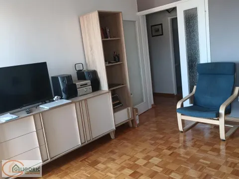Dnevni boravak sa televizorom, policom za knjige i foteljom. - image 3