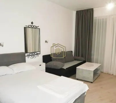 Furnished bedroom with a double bed, sofa, coffee table, and wall mirror. - image 2