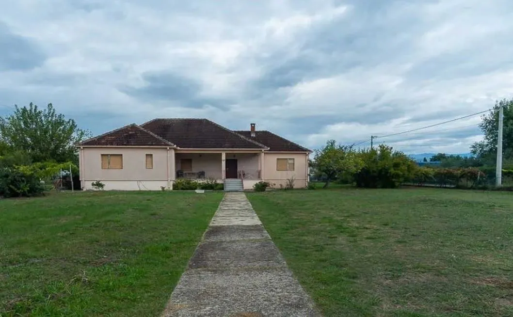 Single-story house with a spacious yard and a pathway leading to the entrance.