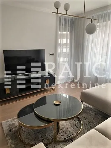 Modern and bright living room with a sofa and television.