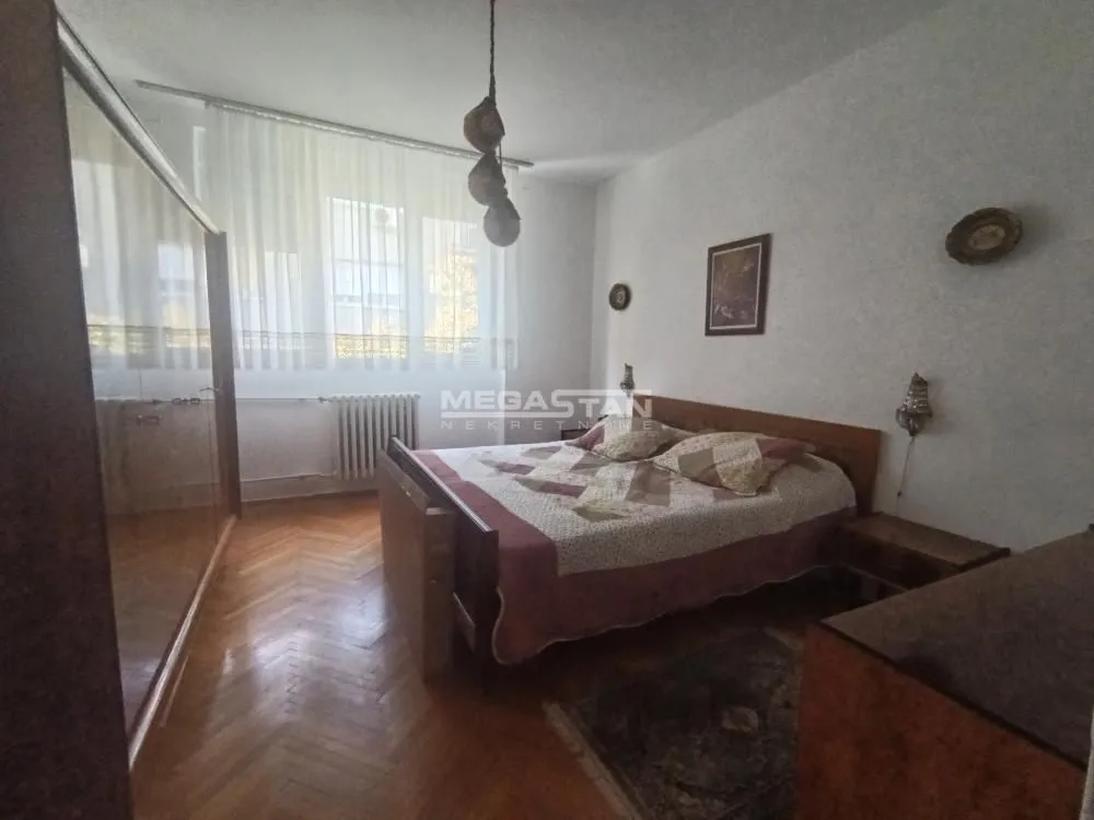 Furnished bedroom with a double bed, wardrobe, and a window.