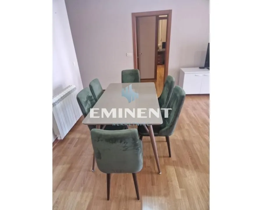 Dining area with a table and green chairs in the living room.