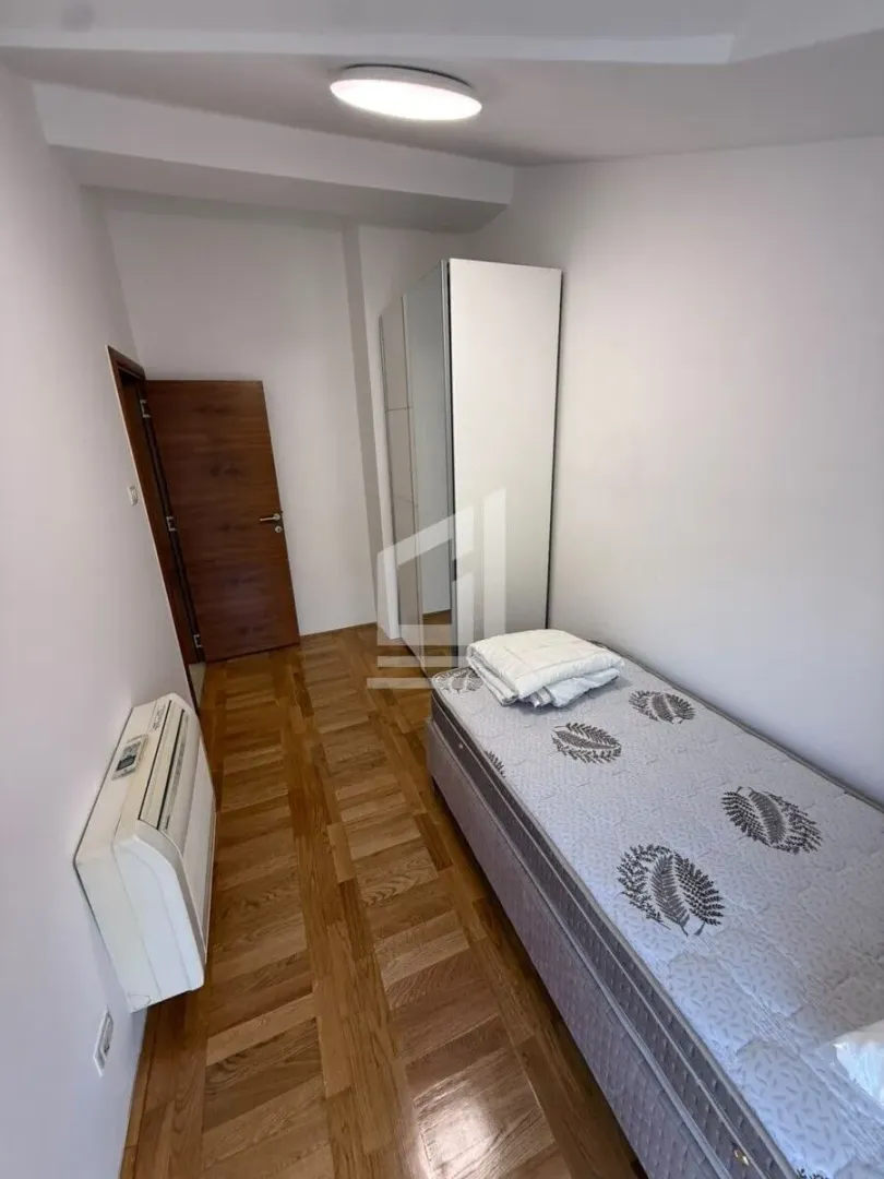 Small bedroom with a bed and a wardrobe.