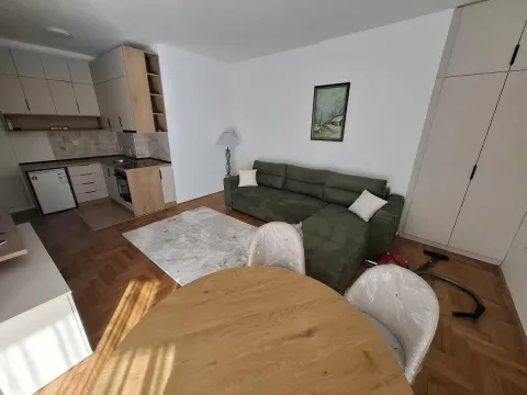 Dnevni boravak sa garniturom, trpezarijskim stolom i kuhinjom u pozadini. - image 5