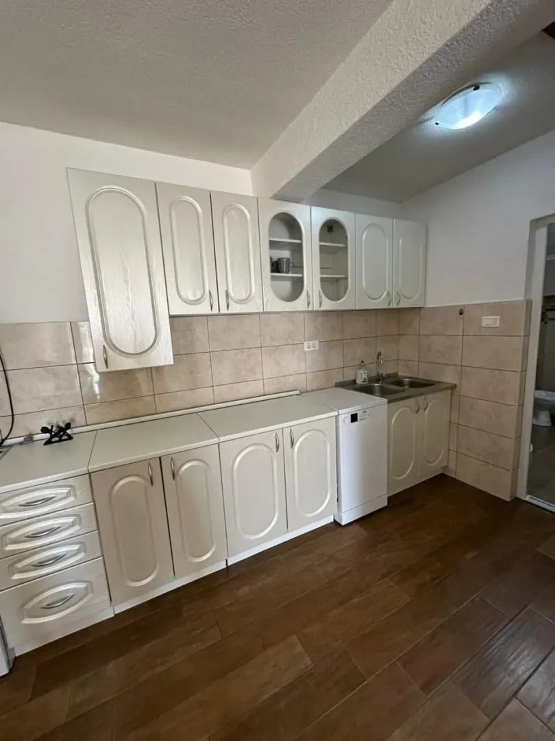 Kitchen with light-colored cabinetry and ceramic tile backsplash.