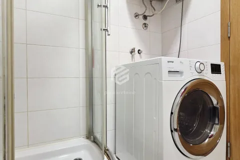 Bathroom with a shower cabin and a washing machine. - image 8