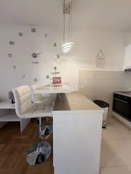 Moderna kuhinja sa šankom, bijelim barskim stolicama i zidnim satom. - image 6