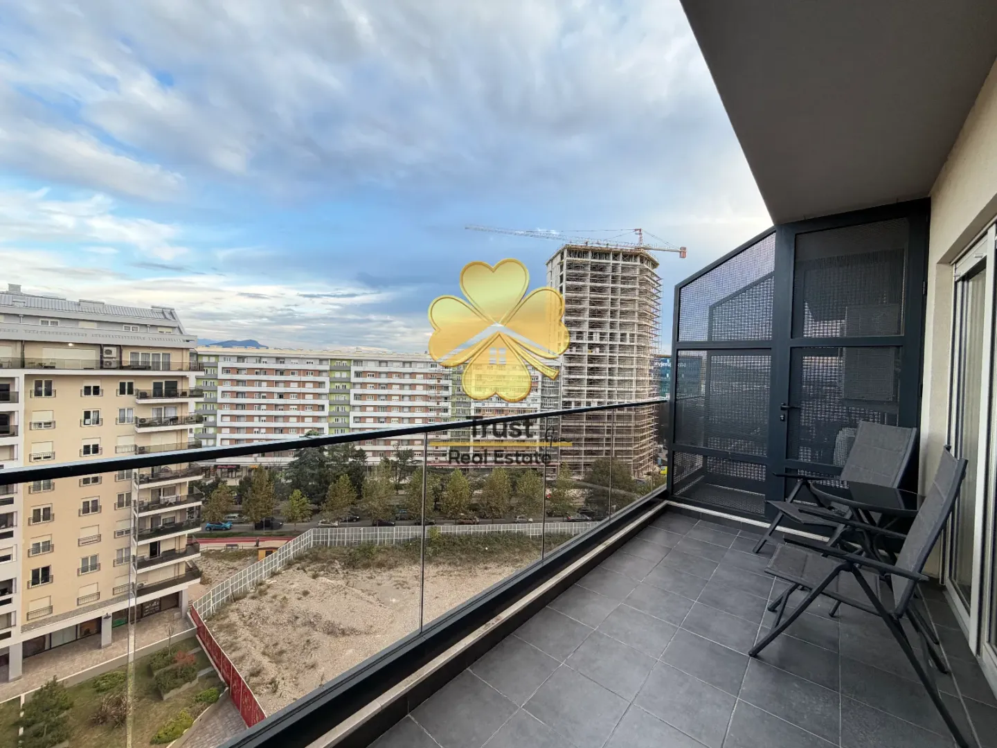 Furnished balcony with seating set and city view.