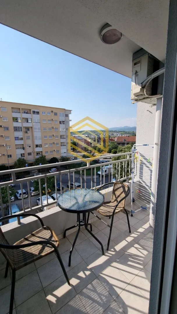 Furnished balcony with a table, chairs, and a view of the surroundings.