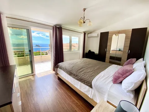 Furnished bedroom with a double bed and access to a terrace with a sea view. - image 8